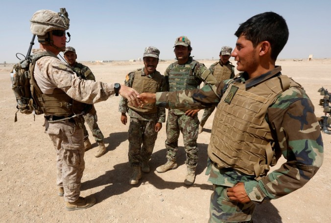 A U.S. Marine (L) shakes hand with Afghan National Army (ANA) soldiers during a training exercise in Helmand province, Afghanistan